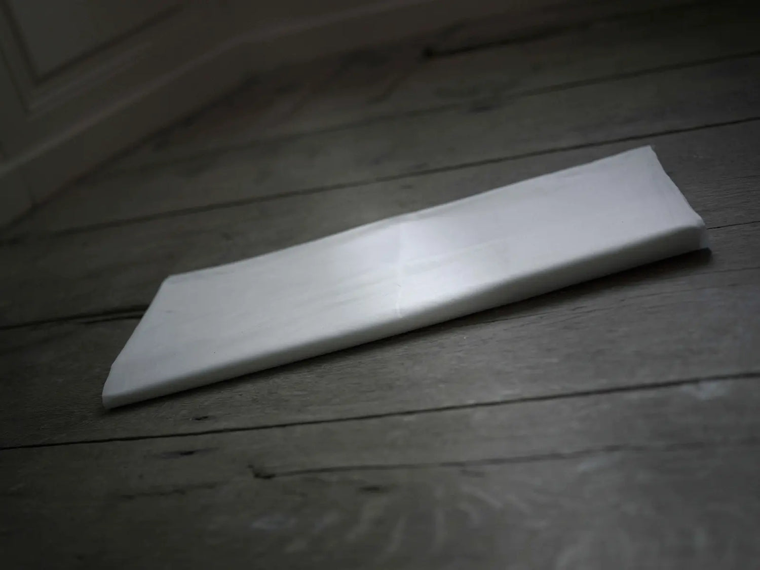 Housse de protection d'un surmatelas pliée sur le sol